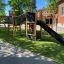 Structure de jeu extérieure pour enfants Challenger Nature II dans une cour d’école avec un toboggan et un pont