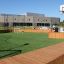 Terrain de sport Multiarena Wooden avec installations de football et de basket-ball dans une cour d’école.