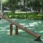 Nature Seesaw dans une aire de jeux avec design en bois et poignées en métal.