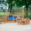 Équipement de terrain de jeu en bois pour Sand & Water Play III avec bancs et tables.