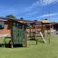 Équipement de terrain de jeu Rope Center dans une cour d’école avec structures d’escalade et maisonnettes de jeu.