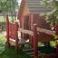 Maisonnette en bois pour enfants avec des accents rouges, Anna's Playhouse.