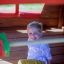Enfant jouant à l’intérieur de Anna's Playhouse en bois.