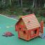 Anna's Playhouse, maison de jeu en bois avec accents rouges dans une aire de jeux colorée