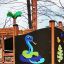 Structure de jeu Jungle castle with slide avec décorations colorées de serpent et de jungle.