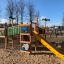 Château de la jungle sur aire de jeux avec toboggan dans un parc.
