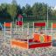Structure de jeu pour enfants Jupiter sur une aire de jeux sablonneuse.