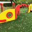 Baby Caterpillar wooden playhouse en rouge et jaune avec une fenêtre circulaire et une petite platefo