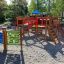 Ensemble de jeux pour enfants Race Track Board avec toboggans et structures d'escalade dans un parc.