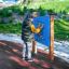 Enfant jouant avec le panneau d'activité extérieur Bingo Board dans un parc.