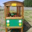 Structure de jeu en bois en forme de bus avec des accents verts et jaunes.