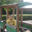 Structure de jeu en bois en forme de bus avec un enfant à l’intérieur.