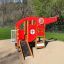 Structure de jeu pour enfants Helicopter rouge et jaune avec toboggan et éléments d’escalade dans un parc