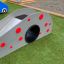 Toboggan de jeu pour enfants, Dottie II single slide avec des points rouges dans une zone herbeuse.