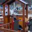 Des enfants jouent sur l’équipement de jeux Delta avec structure en bois et panneaux interactifs.