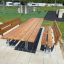 Table & Bench Steel Construction en extérieur dans une aire de loisirs avec de l’herbe et des équipements de jeu