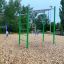 Équipement de jeu extérieur Monkey Bar avec cadre vert et anneaux suspendus dans un parc.