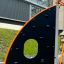 Copernicus steel structure - mur d'escalade noir avec cadre orange sur l'aire de jeux.