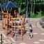 Structure d’escalade de aire de jeux en bois Meru avec toboggans et filets de corde dans un parc