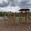 Ensemble de aire de jeux Meru avec toboggan et structure d’escalade dans un parc.