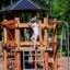 Structure d’escalade de aire de jeux en bois Meru avec des enfants jouant à l’extérieur