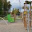 El Dorado wooden playhouse avec éléments d’escalade et accents verts dans une aire de jeux.