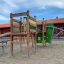 El Dorado wooden playhouse avec toboggan et structure d’escalade dans une aire de jeux.