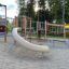 El Dorado wooden playhouse avec toboggan et structures d’escalade dans une aire de jeux