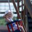 Un enfant profitant d’une balançoire Baby Single Swing dans une aire de jeux.