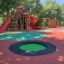 Round trampoline (80 cm) dans une aire de jeux extérieure colorée.
