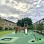 Square trampoline (100 cm) sur une aire de jeux moderne dans un quartier résidentiel.