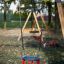 Double Swing sur une aire de jeux avec des arbres en arrière-plan