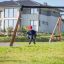 Enfant jouant sur le Double Swing équipement de jeu dans un quartier résidentiel.