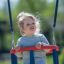 Enfant sur Double Swing dans une aire de jeux.