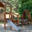 Galapagos wooden playhouse with slide dans un parc