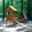 Galapagos wooden playhouse with slide dans un cadre de aire de jeux en forêt