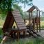 Galapagos wooden playhouse with slide dans un parc.
