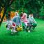 Enfants jouant sur l’équipement de aire de jeux Grasshopper rocking sur une pelouse