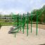 Structure de fitness extérieure verte, Grandis Training Set, dans un parc avec base en sable.
