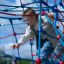 Un enfant grimpe sur l’équipement de terrain de jeu Autan climbing net par une journée ensoleillée