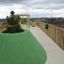 Surface de jeu Wetpour 45 en forme de colline verte avec des arbres sur un toit-terrasse.