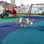 Aire de jeux recouverte d'un revêtement en caoutchouc Wetpour 45, avec toboggans et ressorts à bascule