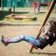 Fille se balançant sur Twister w/ swing dans une aire de jeux