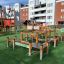 Équipement de terrain de jeu en bois Balance Course sur gazon artificiel dans une zone urbaine.