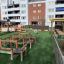 Terrain de jeu extérieur avec équipement Balance Course près d’immeubles d’appartements.