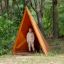 Enfant debout à l'intérieur de Tipi Nature wooden house sur une aire de jeux en forêt