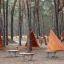 Équipement de jeu Tipi Nature wooden house en milieu forestier avec trois cabanes triangulaires en bois