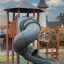 Équipement de aire de jeux Khumbu castle with slide en bois et métal avec un toboggan gris incurvé.