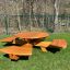 Round table & benches en bois placé dans une zone herbeuse