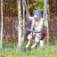 Enfant profitant d'un Wooden Baby double swing dans une aire de jeux arborée